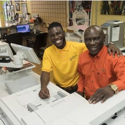 Two printers at work behind the counter at Minuteman Press Philadelphia